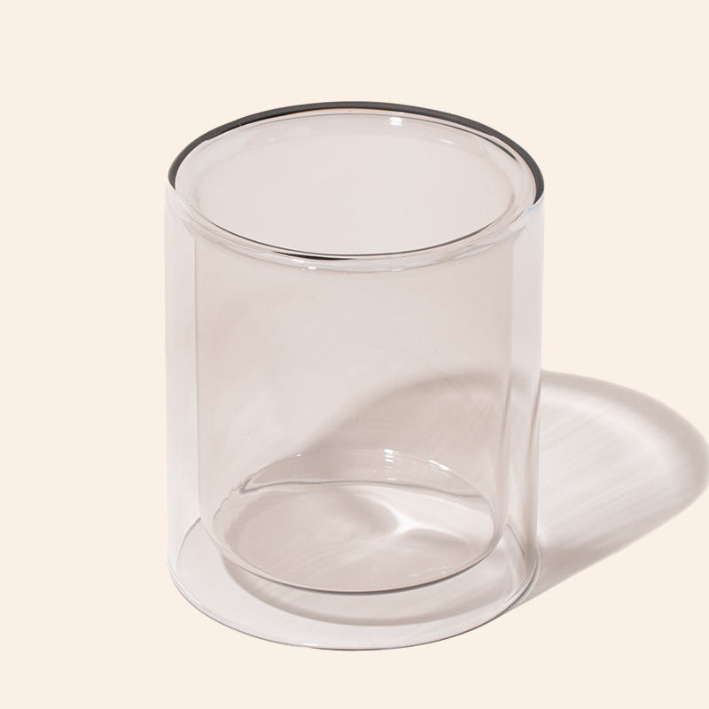 Clear glass candle holder on a light beige background