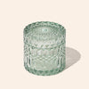 Green textured glass jar on a light beige background