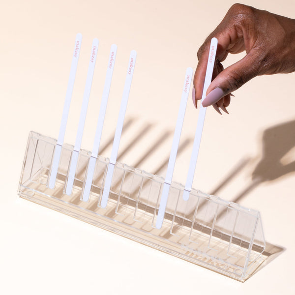 Clear acrylic blotter strip holder keeping fragrance test strips upright and organised on a work surface