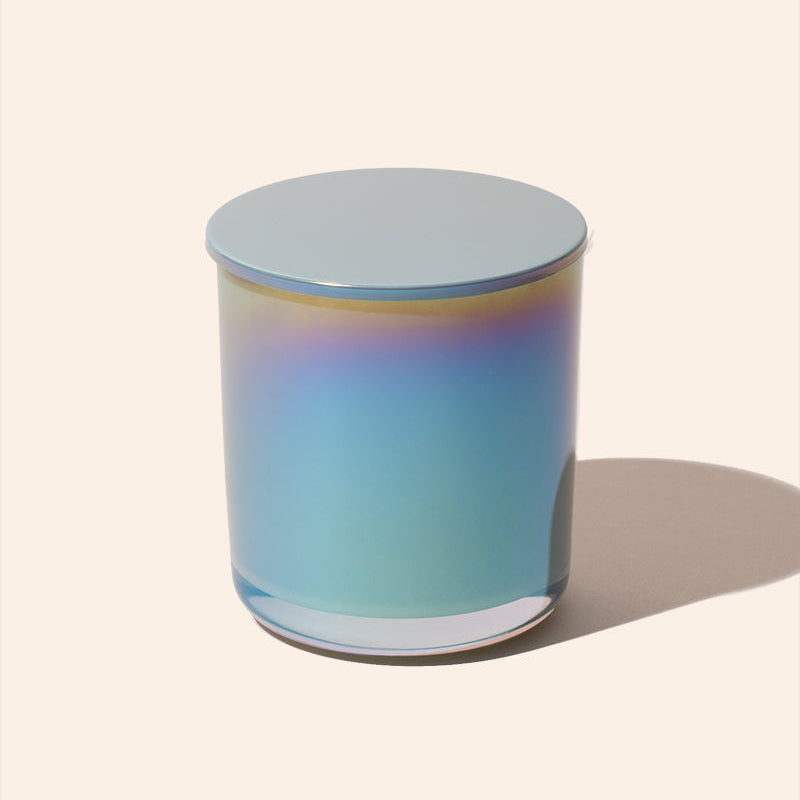 Gradient-colored glass candle on a light beige background