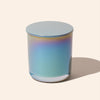 Gradient-colored glass candle on a light beige background