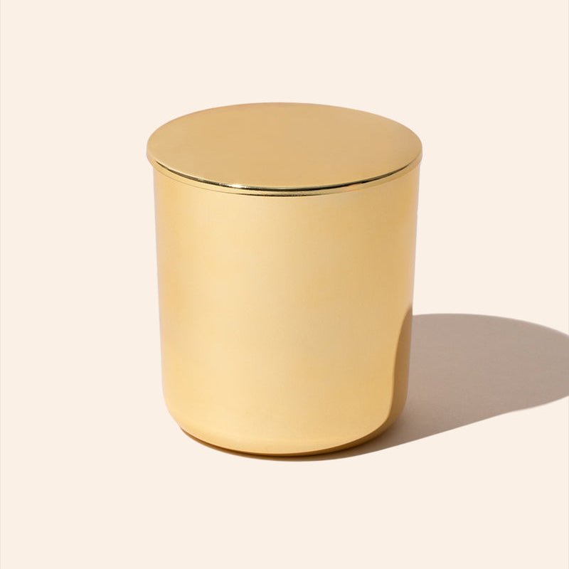 Gold cylindrical container on a beige background