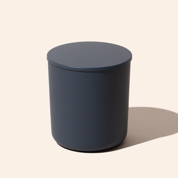 Dark blue cylindrical container on a beige background