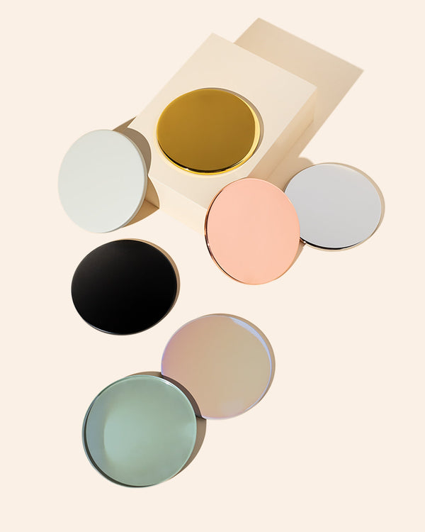 Thin metal candle lids in various finishes resting on 12 oz Aura candle jars without gasket