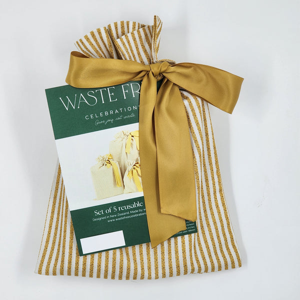 Set of reusable bags with a gold ribbon and a Waste Free Celebration card on a white background