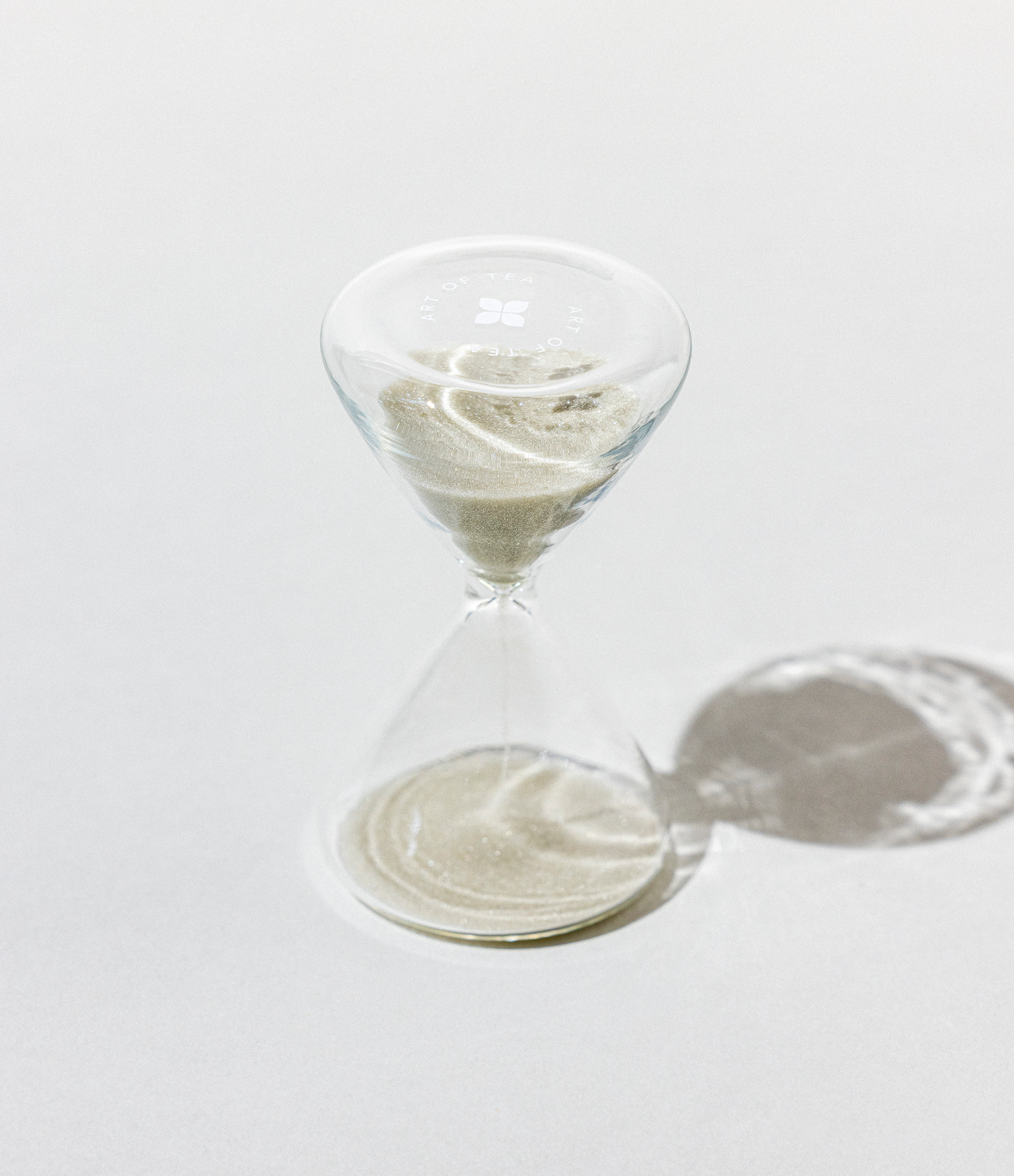 Marble-patterned hourglass on a white surface