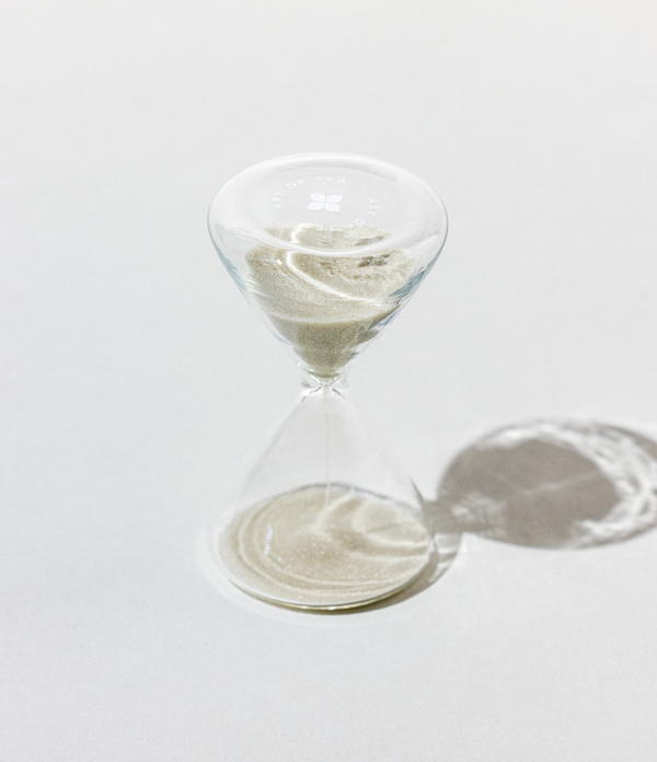 Marble-patterned hourglass on a white surface