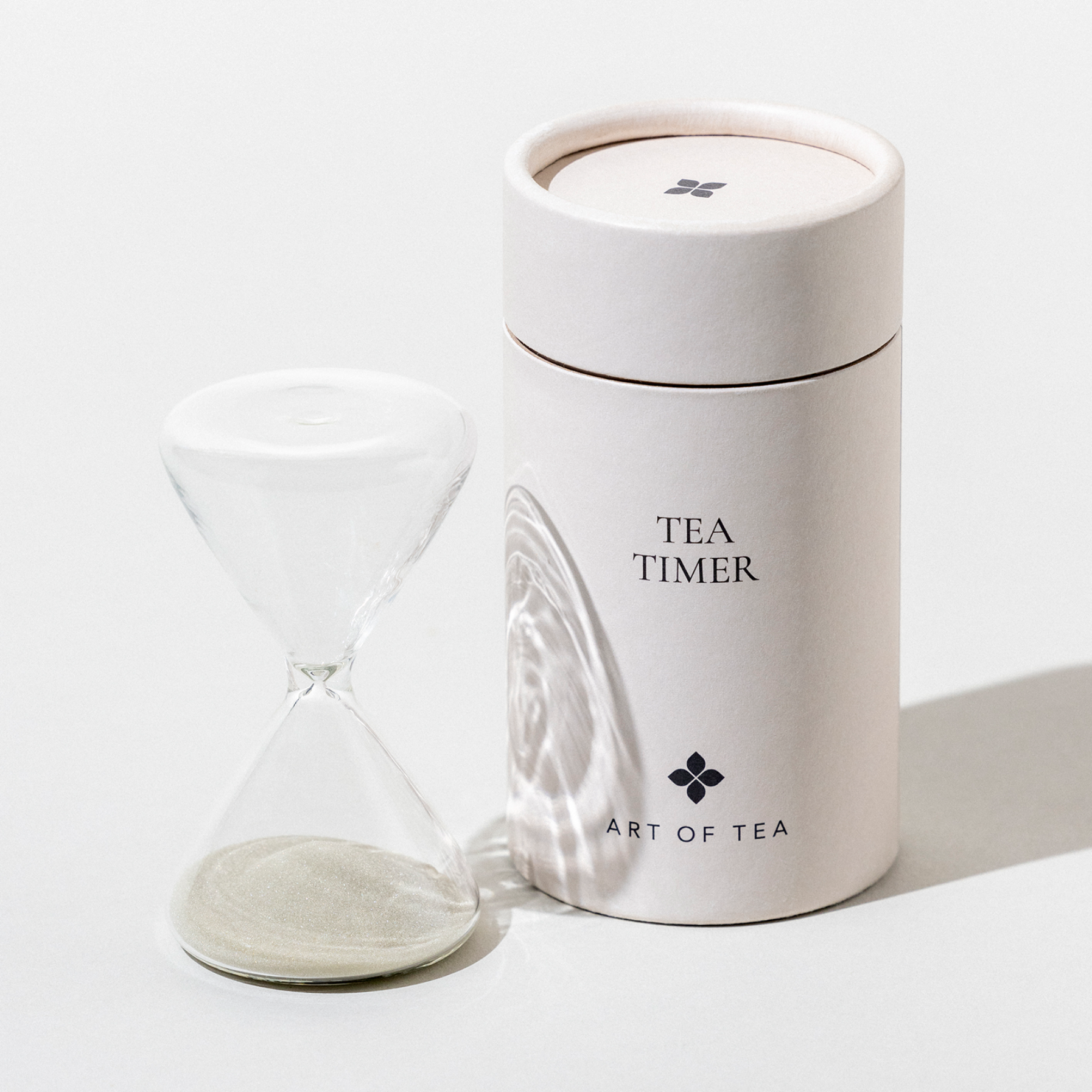 White tea timer with a glass container on a white background