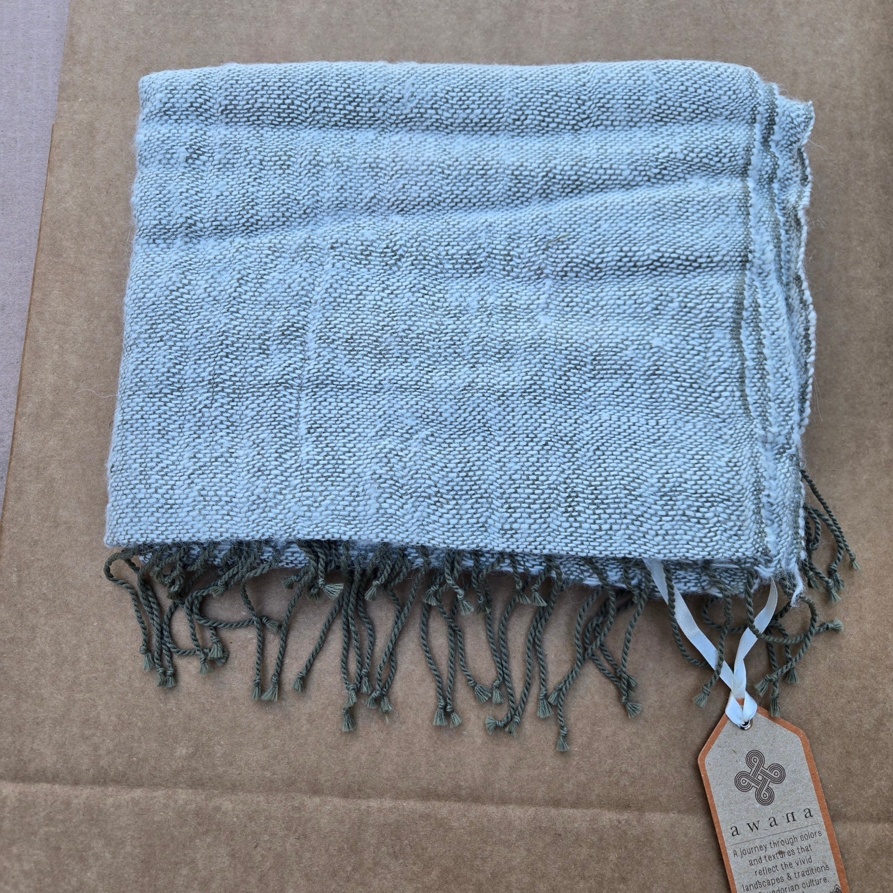 Close-up of Awana Alpaca Pashmina showing natural texture and woven detail in green and nutmeg brown