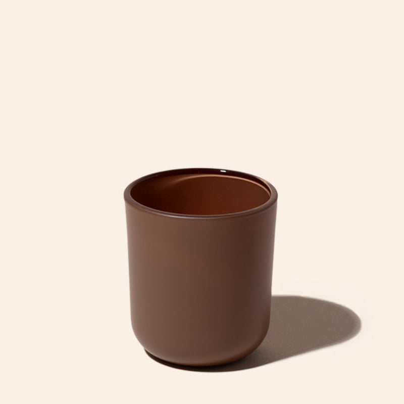 Brown ceramic cup on a beige background