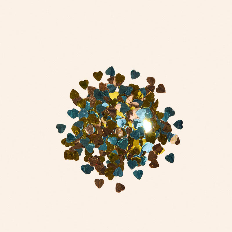 Colorful heart-shaped confetti on a beige background