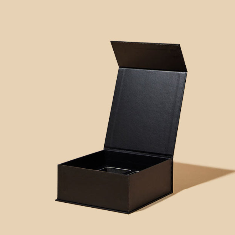 Black rectangular box with a lid on a beige background