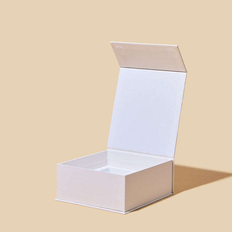 White cardboard box with a lid on a beige background