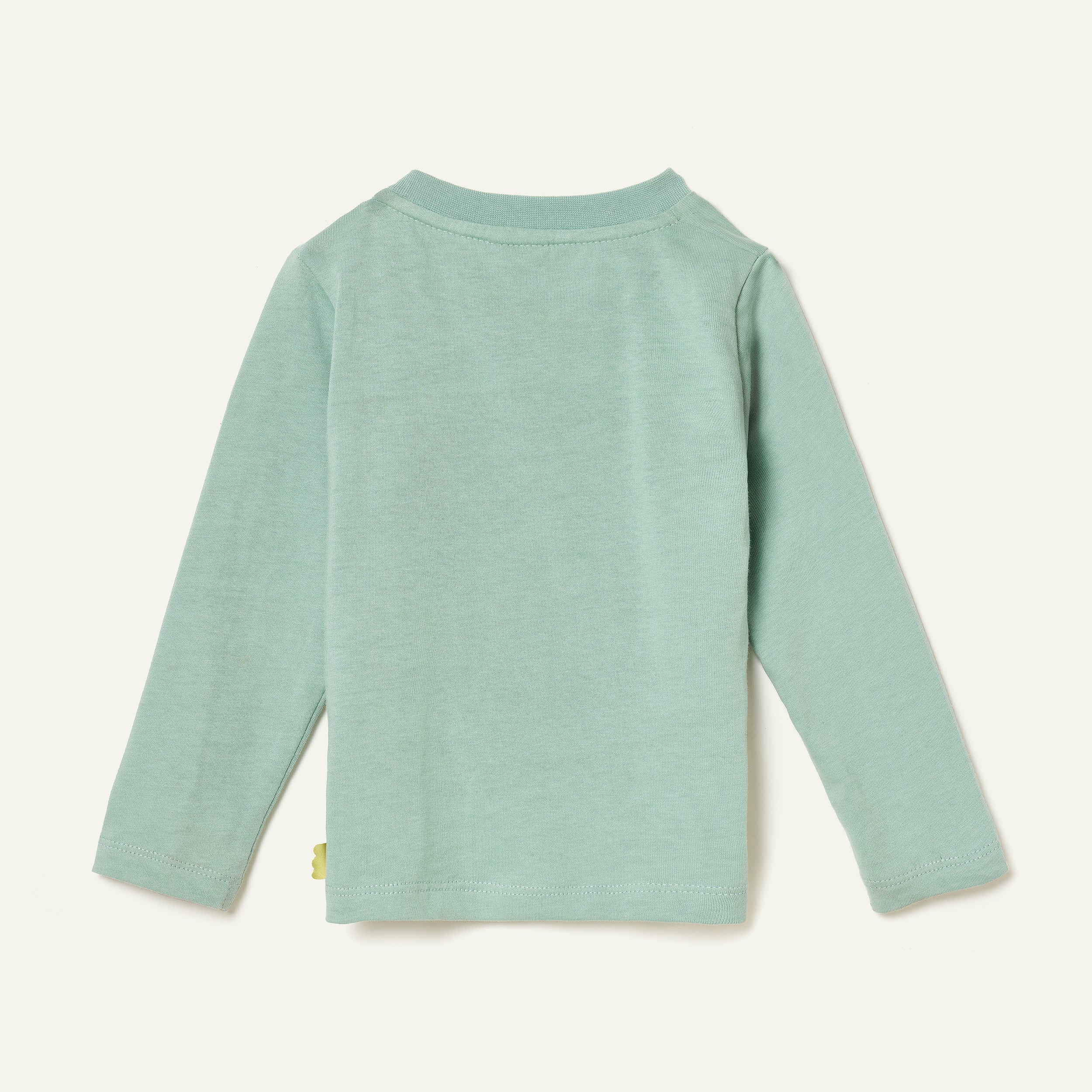 Side view of a child in the Mon Coeur Snowy Pine unisex long-sleeve tee made from recycled and organic cotton