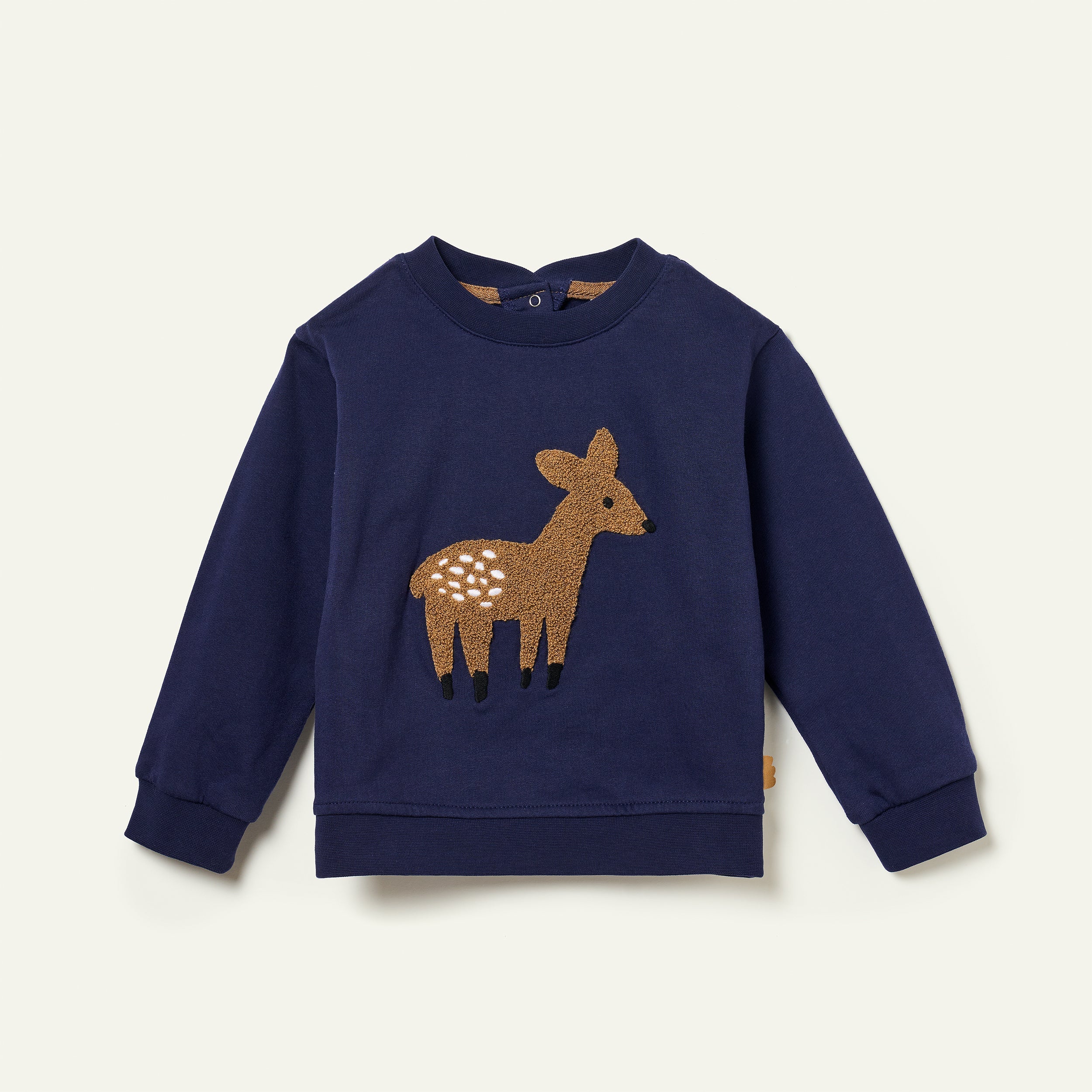 Navy blue sweatshirt with a deer applique on a light beige background