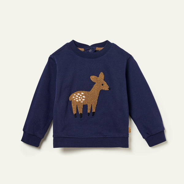 Navy blue sweatshirt with a deer applique on a light beige background