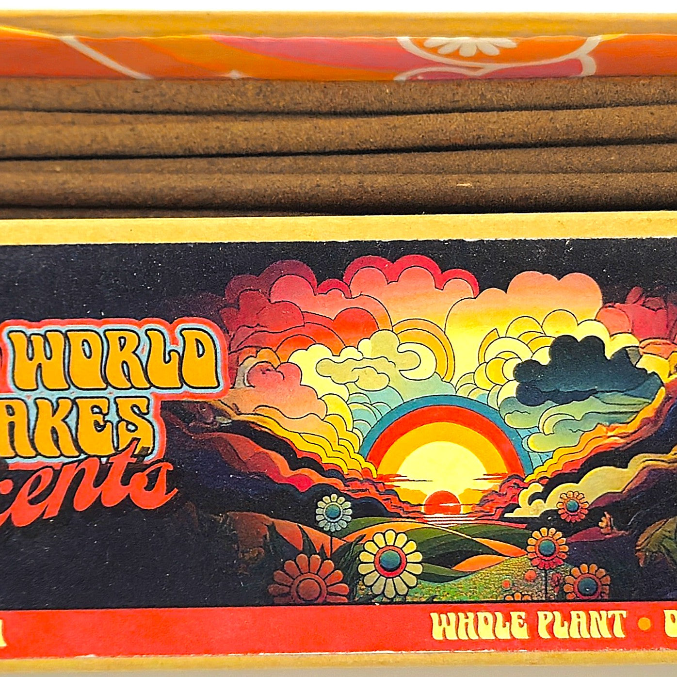 Incense sticks with a colorful box featuring a sunset design and text.