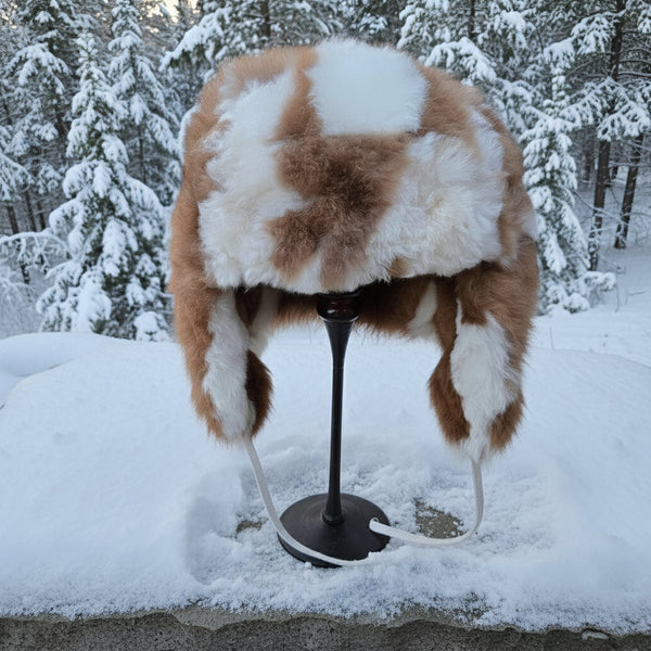 Fur hat on a stand in a snowy outdoor setting
