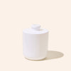 White ceramic jar with a lid on a beige background