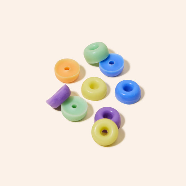 Colorful plastic beads on a light beige background