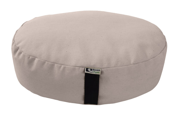 Beige meditation cushion with a black strap on a white background