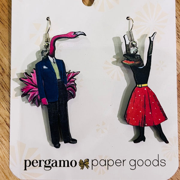 Earrings of a flamingo in a suit and a person in a dress on a Pergamo Paper Goods card.