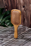 Desesh bamboo paddle hair brush in use, detangling and smoothing hair naturally