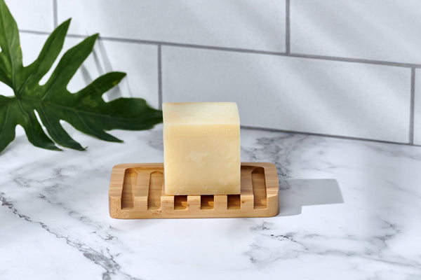 Bamboo rectangular soap rack with natural polished finish placed beside a bathroom sink