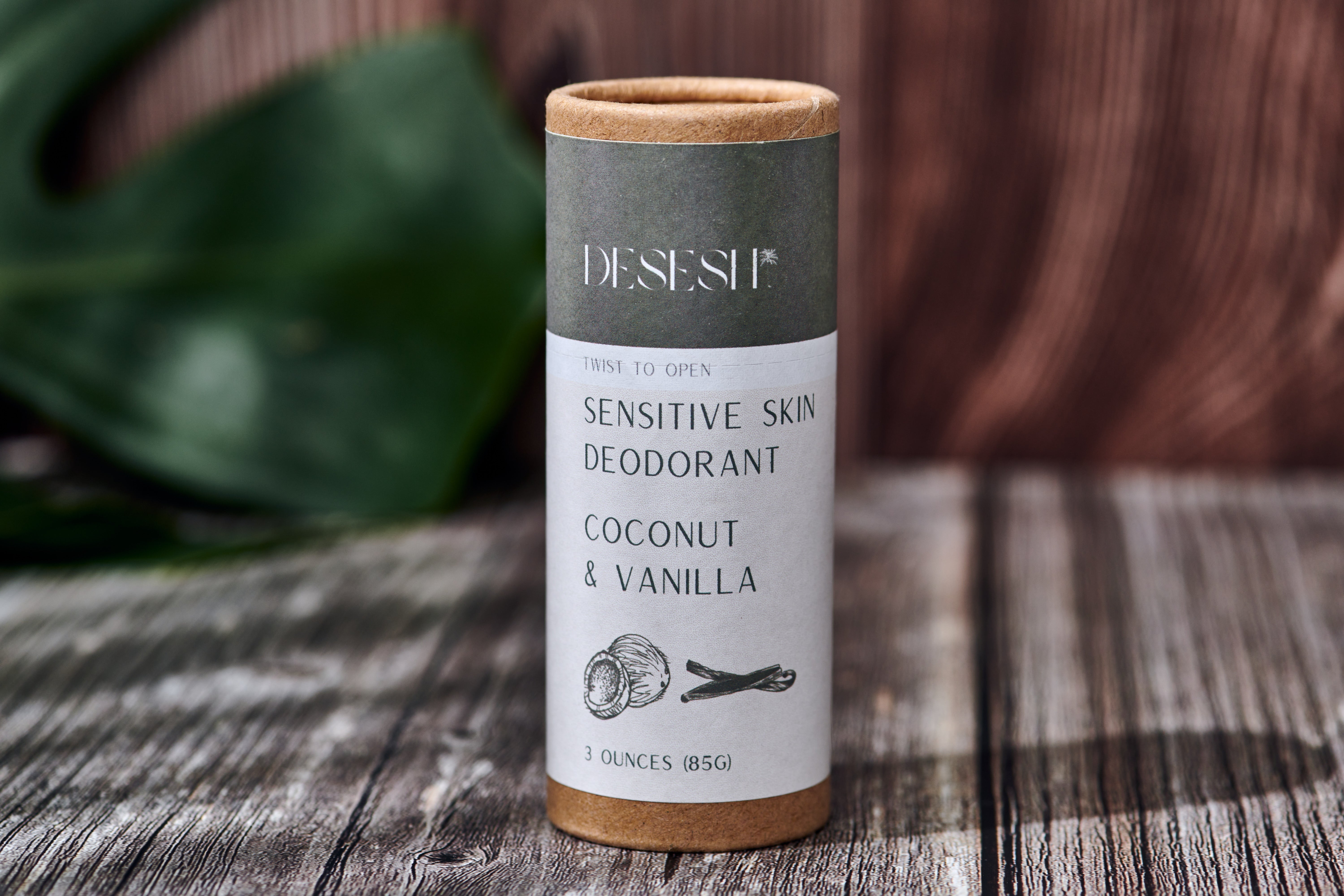Deosesh sensitive skin deodorant container on a wooden surface with green leaves in the background