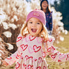 Baby wearing Mon Coeur long sleeve ruffle dress with heart print in recycled cotton