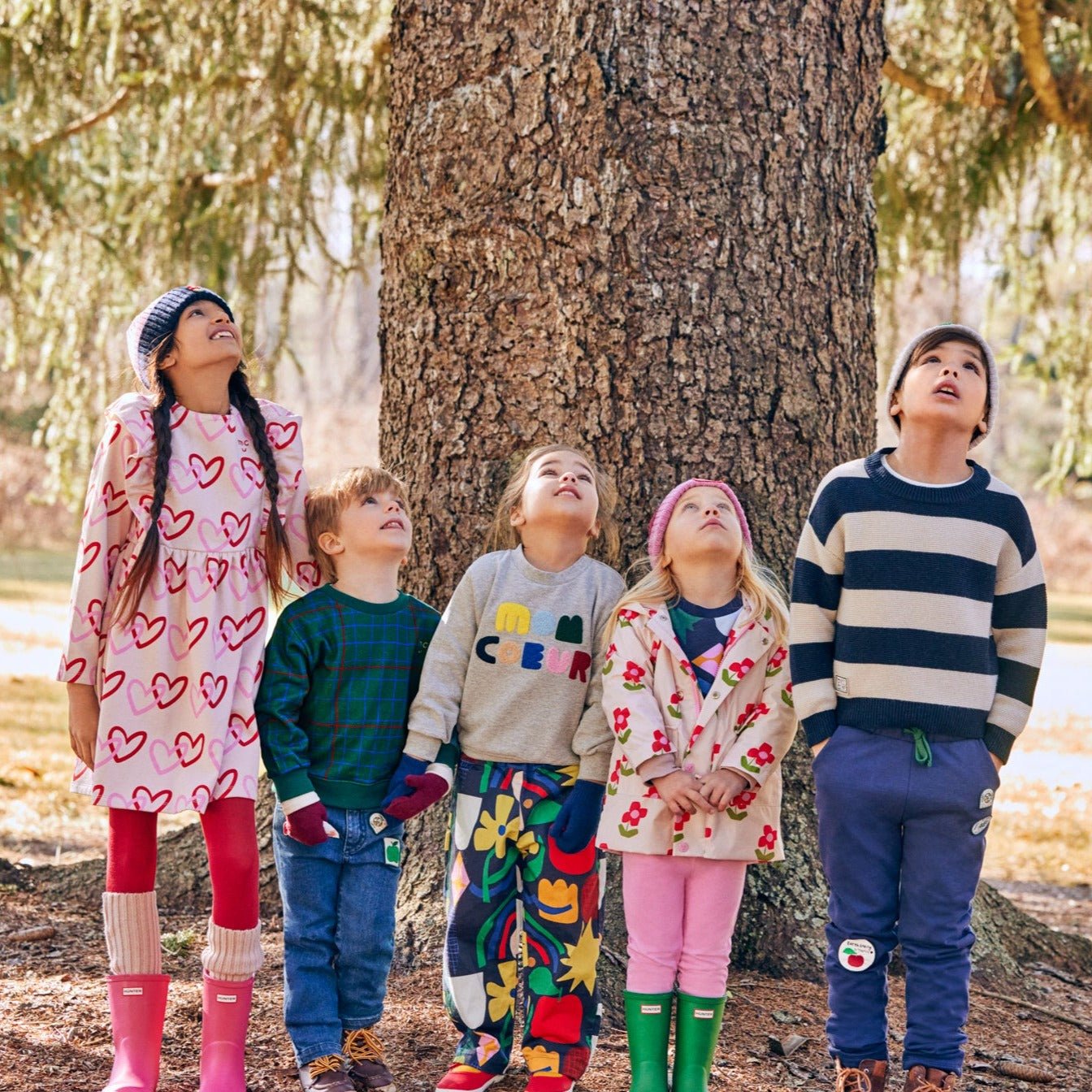 Baby wearing Mon Coeur hearts ruffle dress styled with leggings for cool weather