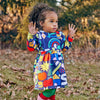 Baby wearing the Mon Coeur recycled cotton ruffle dress in a lifestyle setting, styled with the high-waist flared skirt and long sleeves