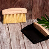 Close-up of Desesh mini wood broom with natural sisal bristles and black metal dustpan