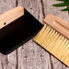 Detail shot of natural wood handle and sisal bristles on Desesh mini broom and black dustpan set