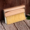 Wooden brush with yellow bristles on a wooden surface
