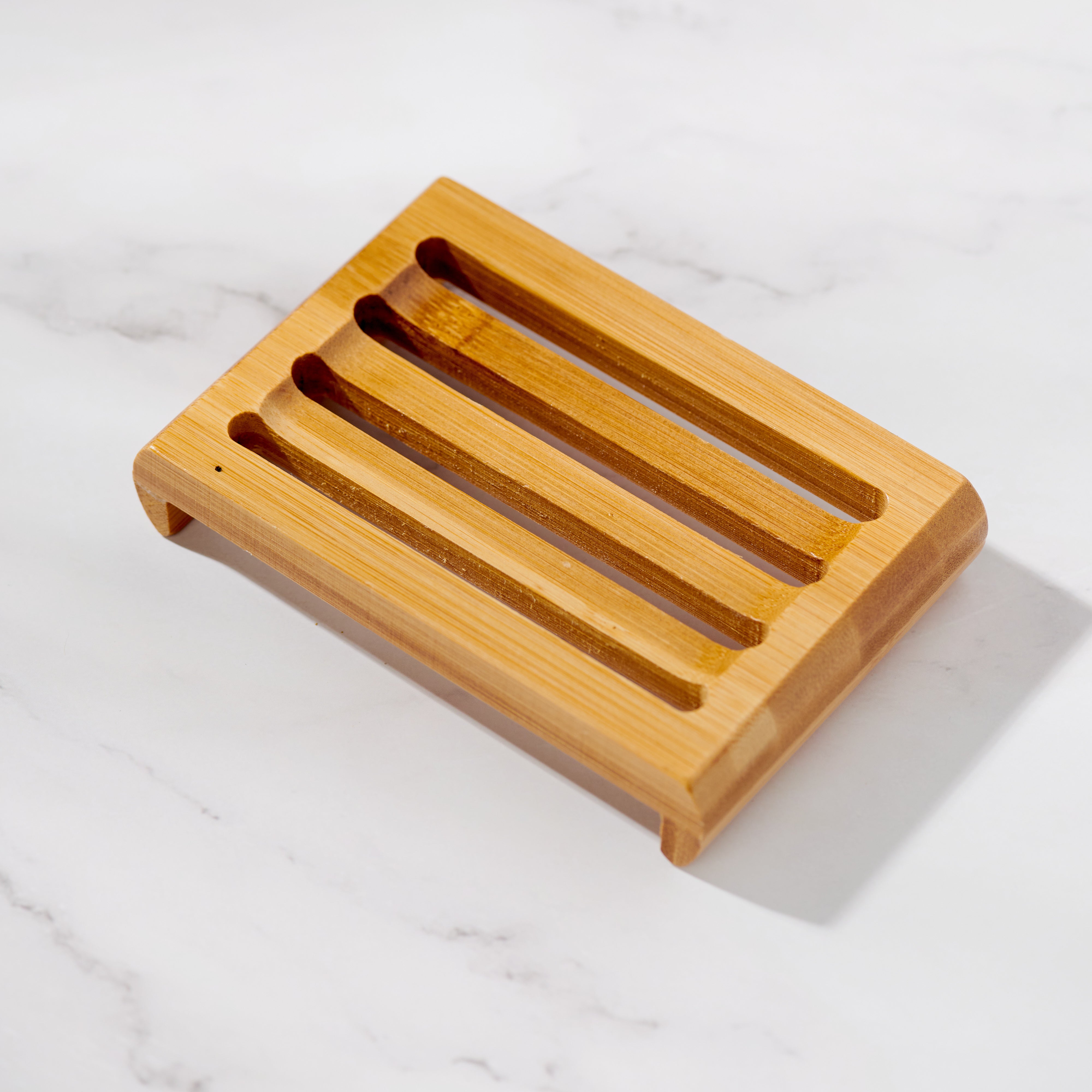 Bamboo platform soap dish from above showing four drain slots