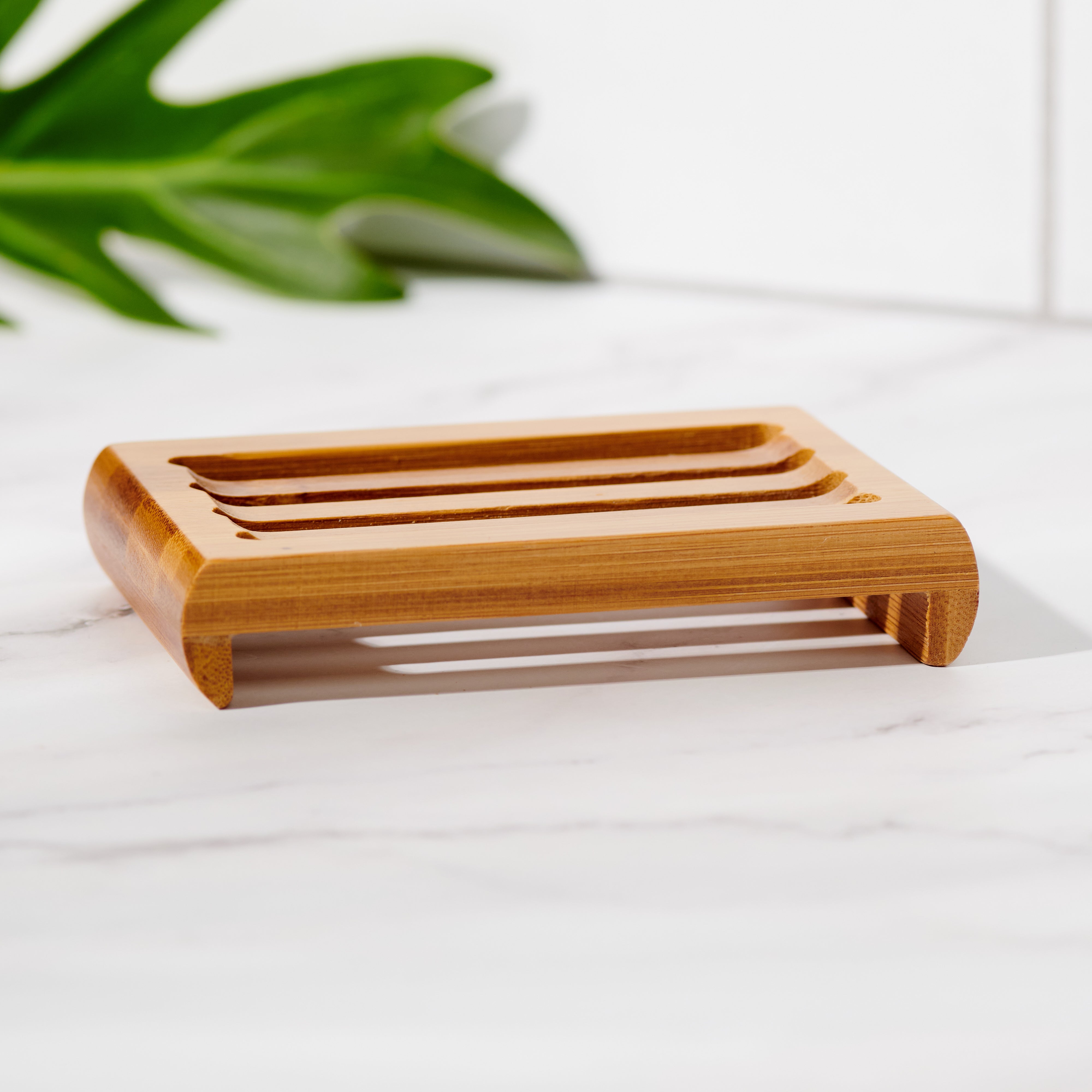 Close-up of slatted bamboo soap dish holding a bar of soap