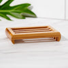 Close-up of slatted bamboo soap dish holding a bar of soap