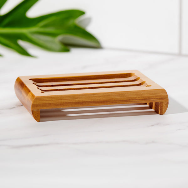 Close-up of slatted bamboo soap dish holding a bar of soap
