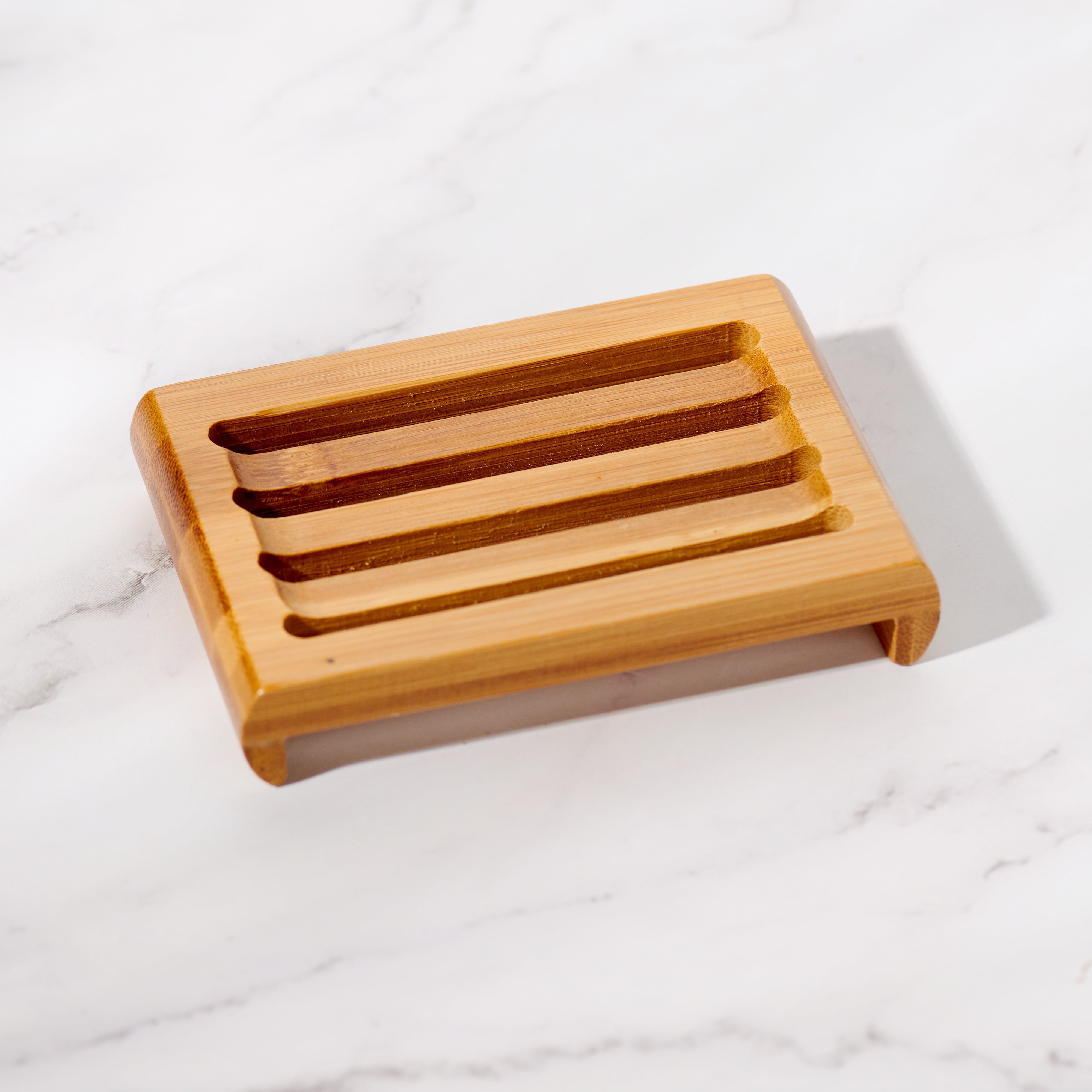Natural bamboo soap dish next to bar soap and eco-friendly bathroom accessories