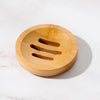 Bamboo circular soap dish beside a bar of soap in a minimal bathroom setting