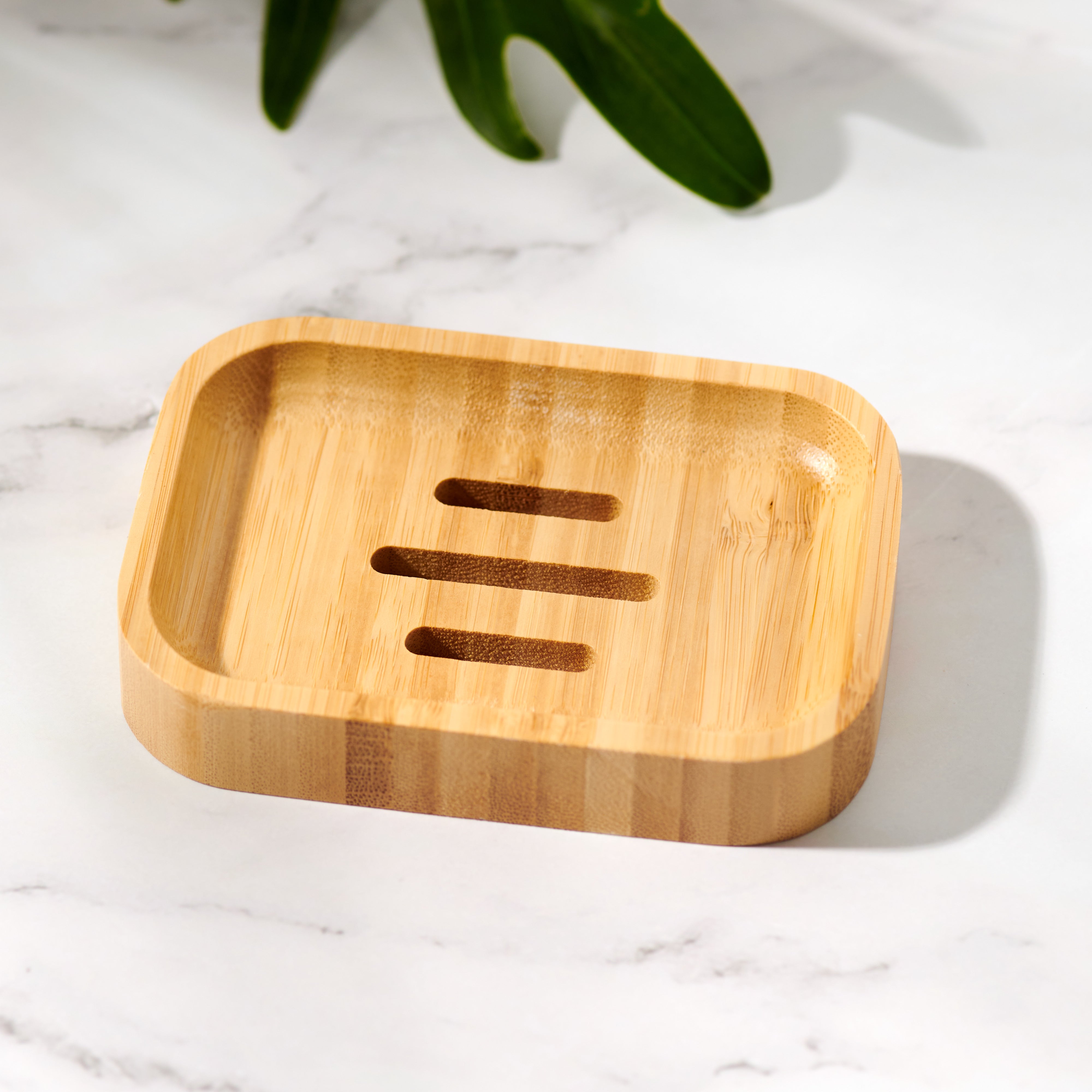 Natural bamboo soap dish holding a bar of soap on a bathroom countertop