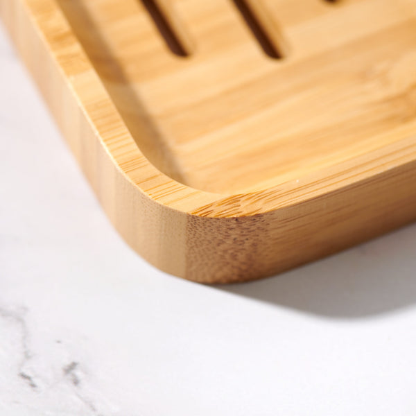 Close-up of slatted bamboo soap dish showing polished finish and curved profile