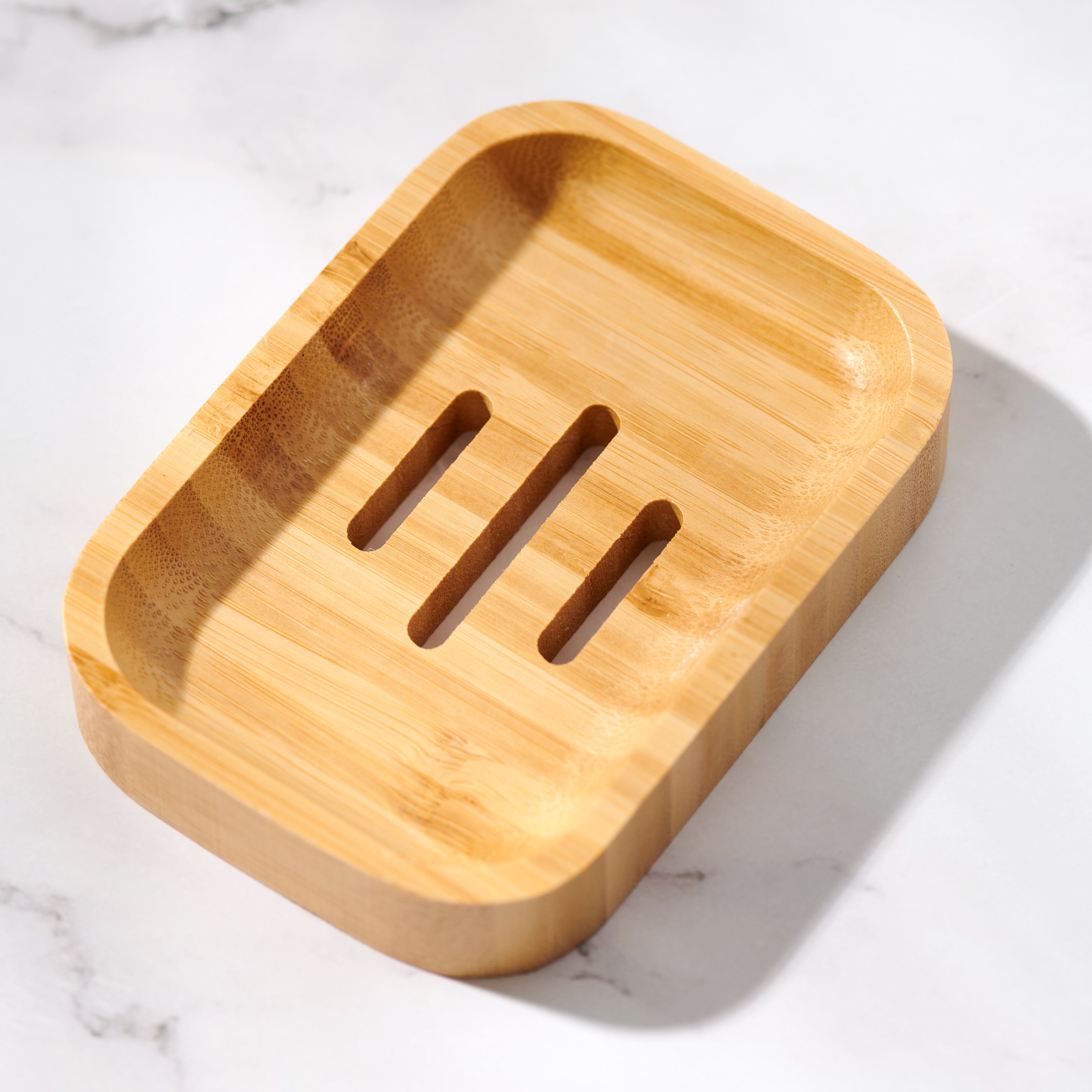 Desesh bamboo soap dish styled on a bathroom shelf next to bar soap and shampoo bars