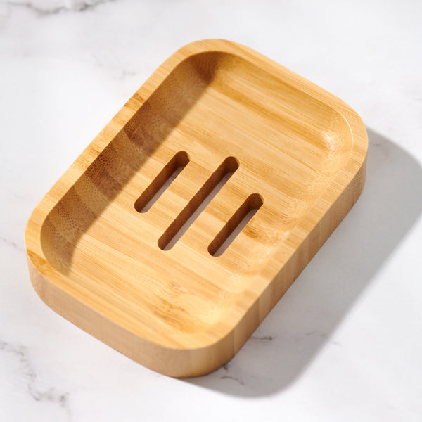 Desesh bamboo soap dish styled on a bathroom shelf next to bar soap and shampoo bars