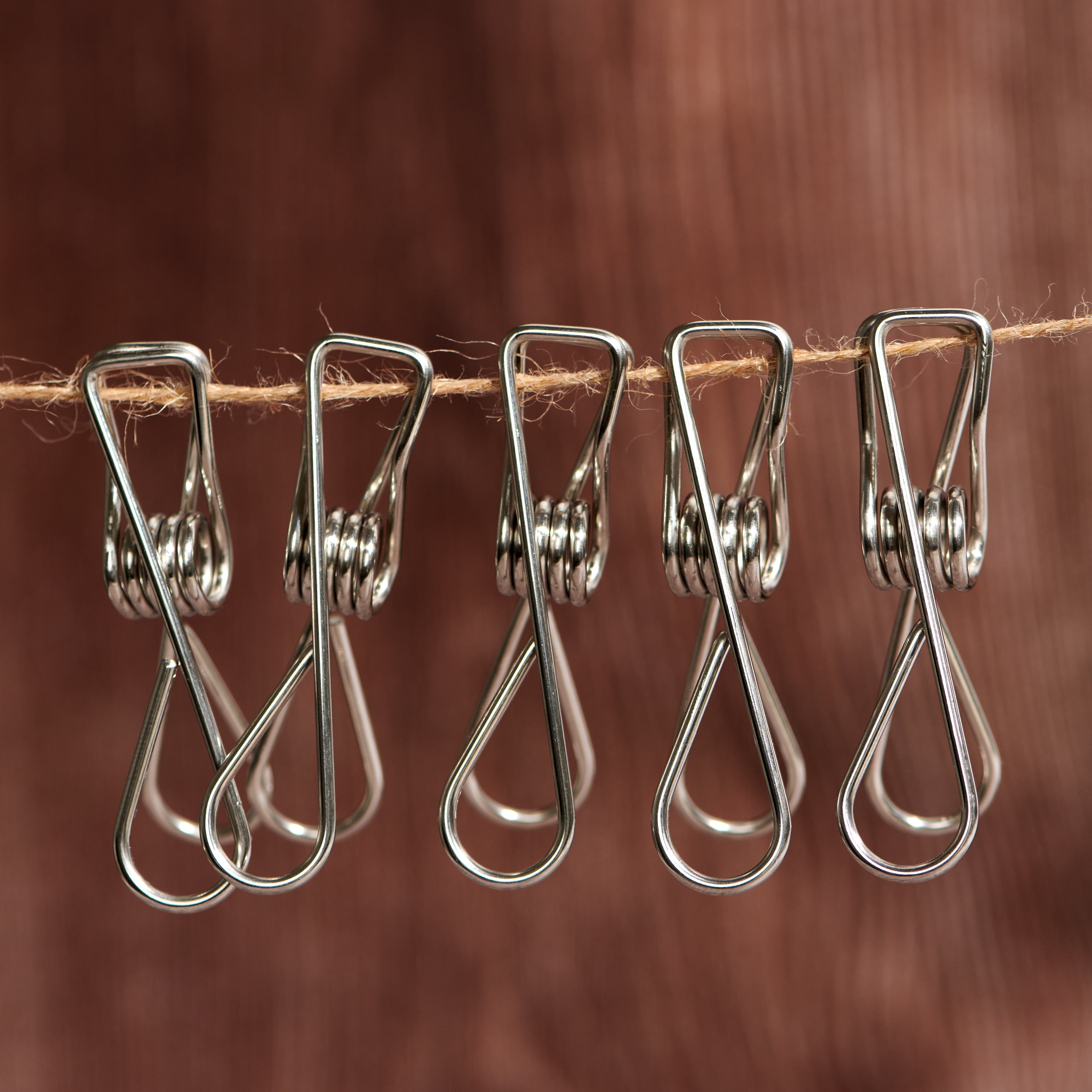 Stainless steel clothes pegs clipped onto laundry line demonstrating firm grip on fabric