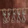 Stainless steel clothes pegs clipped onto laundry line demonstrating firm grip on fabric