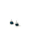 Flat lay of faceted teardrop stud earrings in pink and blue zircon on neutral background