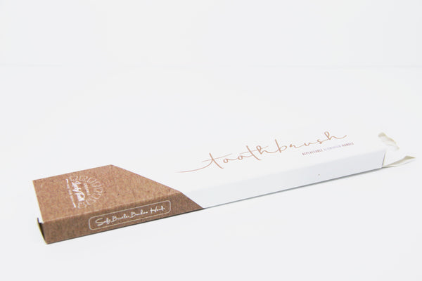 Packaged toothbrush with cardboard holder on a white background