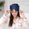 Woman wearing a blue sleep mask with a blurred indoor background